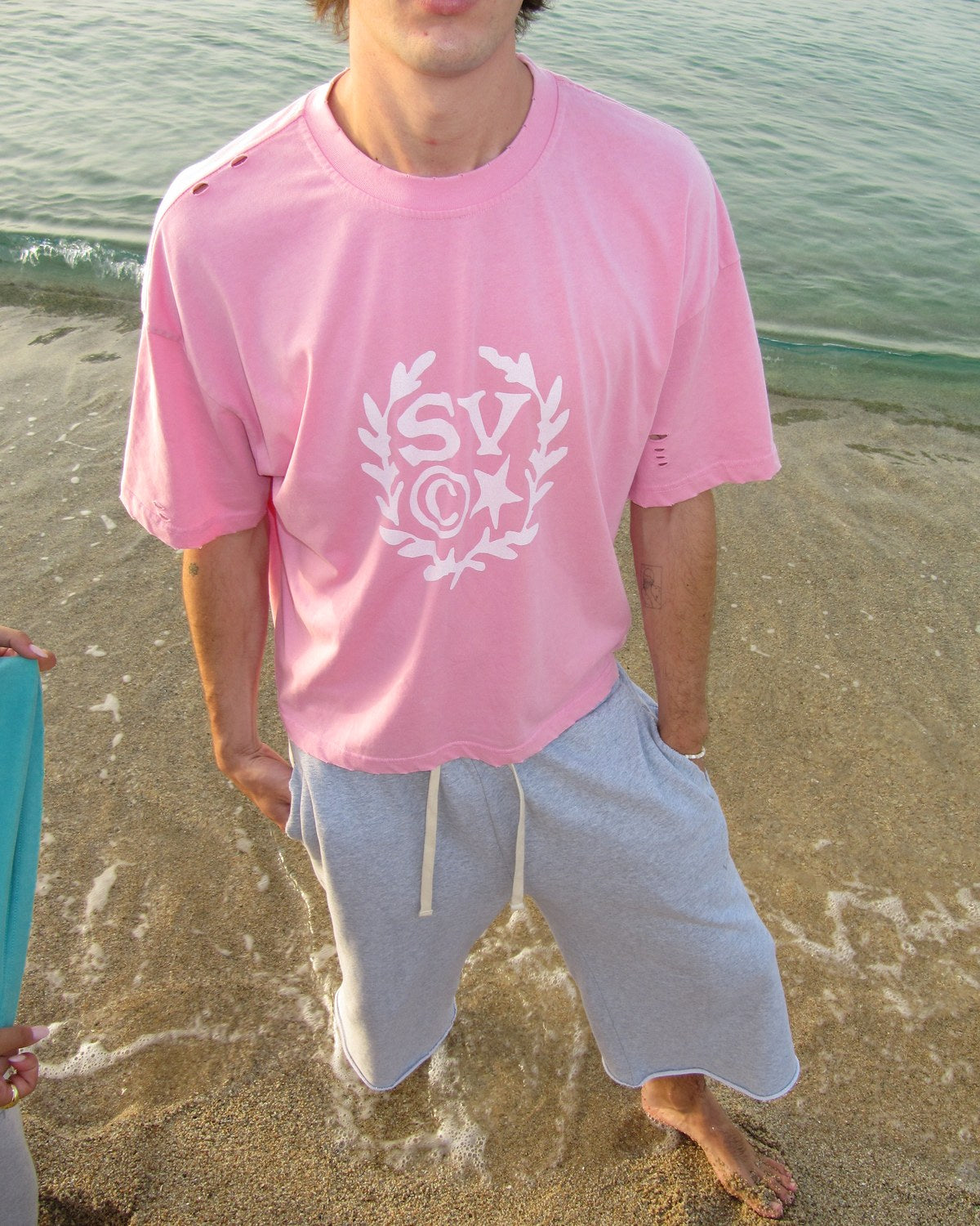 University Pink T-shirt i Yellow Star Gray Pant a la platja