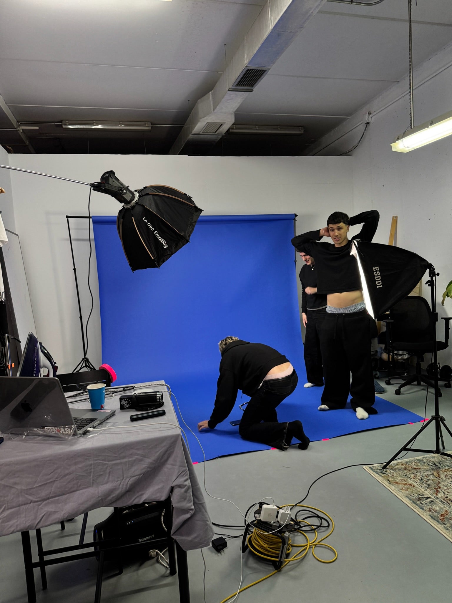 Equipo de stemvius preparando el primer shooting delante de un fondo azul de estudio.