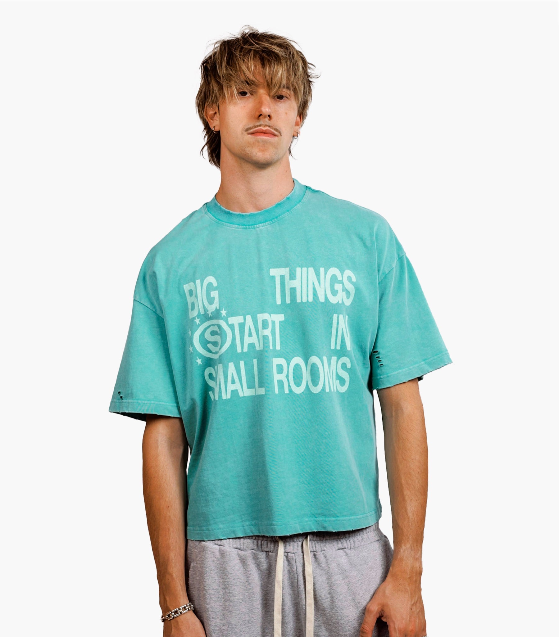 Modelo con Dreamer Green T-Shirt verde y Yellow Star Gray Pant gris sobre fondo blanco.